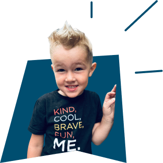 A smiling young boy with spiky blonde hair wearing a black shirt that says "KIND, COOL, BRAVE, FUN, ME."