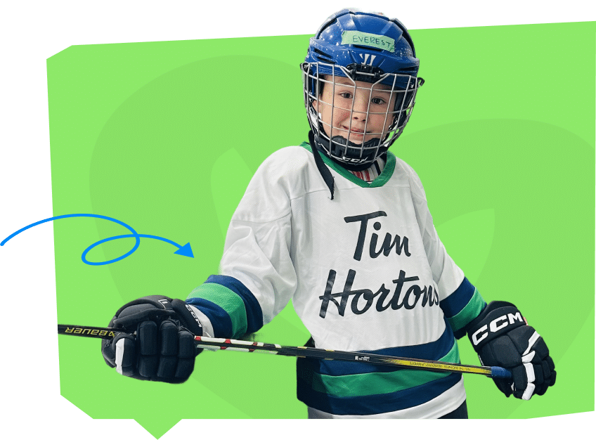 A young hockey player wearing a white jersey with "Tim Hortons" printed on it, holding a hockey stick and wearing a helmet. The background is a bright green color.